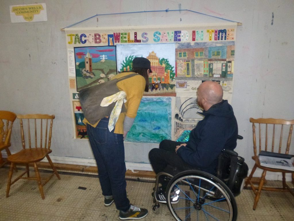 A room packed with people seated and standing for a presentation