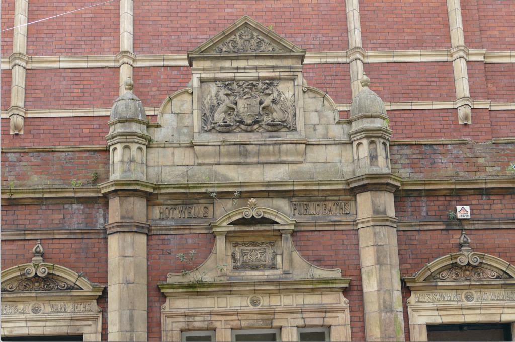 Front facia of the baths, highlighting stonework design and words “HotwellsPublic Baths”