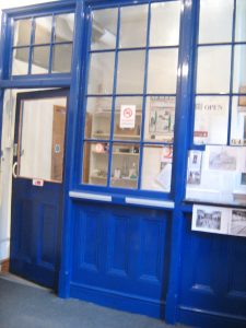 Photo of glazed wall and door in wooden frame painted blue, separating off anoffice