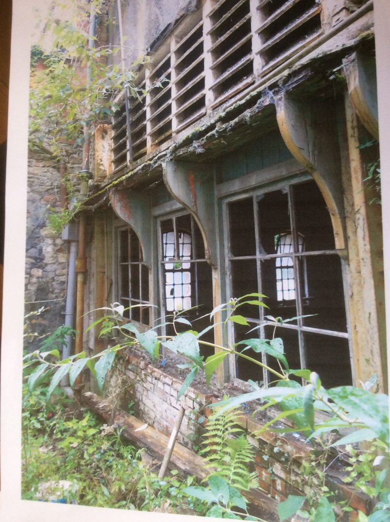 Photo of screen at the end of the boiler house, showing broken windows, withvents above