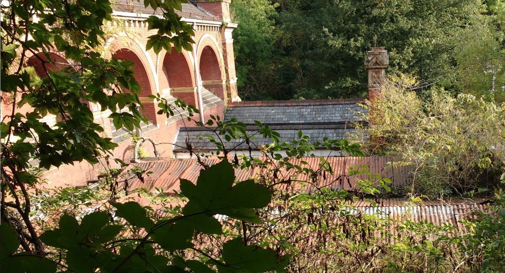 Photo of side of main structure with smaller roofs coming out from it, toppedin tiles or corrugated tin